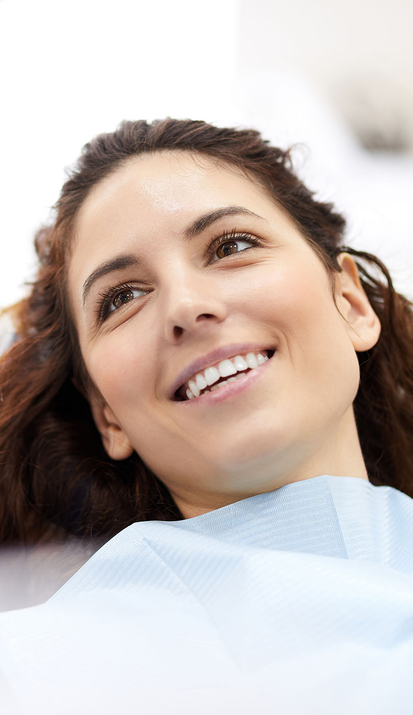 The image shows a modern dental or medical office interior with a dental chair, equipment, and a clean, professional environment.