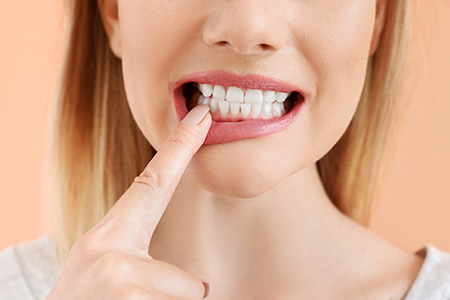 The image depicts a woman with a toothbrush, brushing her teeth.